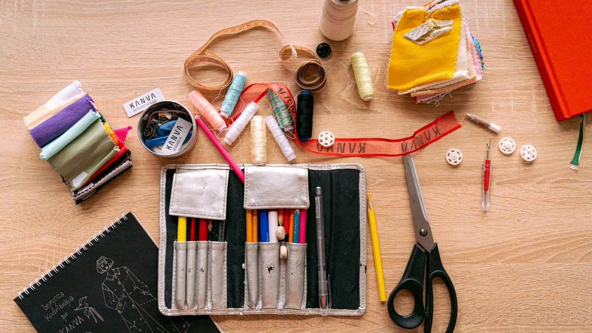 Kit de costura com linhas, tesoura e tecido visto de cima