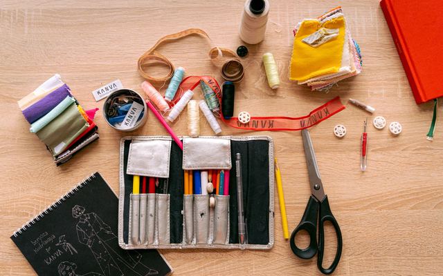 Kit de costura com linhas, tesoura e tecido visto de cima