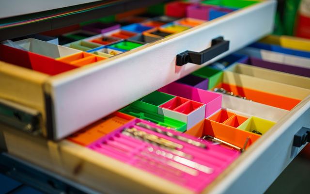 Gaveta organizada com compartimentos coloridos