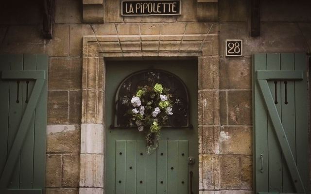 Porta verde rústica decorada com uma guirlanda
