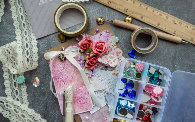 Materiais de artesanato e um cartão feito à mão vistos de cima